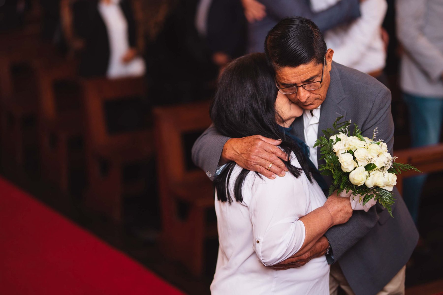 Couple embracing in the church, bouquet in hand